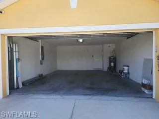 Spacious garage featuring a concrete floor, painted block walls, and an overhead light fixture