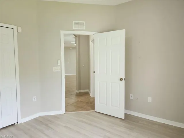 Interior room featuring light wood-finish flooring, neutral wall paint, and white trim
