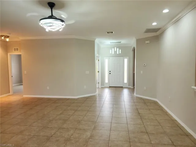 Great room. Expansive tiled flooring throughout, complemented by crown molding and recessed lighting