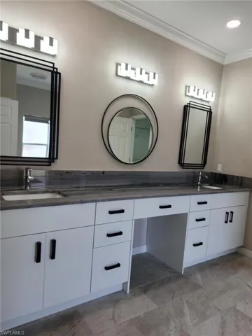 Dual vanity with a stone countertop, under-mount sinks, and matte black hardware