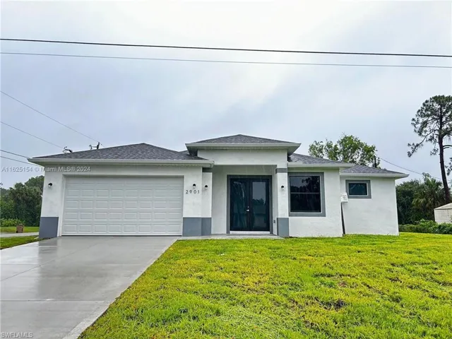View of front of property featuring a garage and a front yard