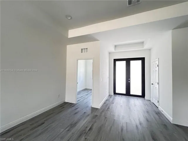 Entrance foyer featuring dark wood-type flooring and french doors