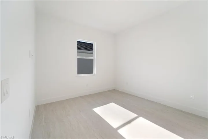 Spare room featuring baseboards and wood finished floors