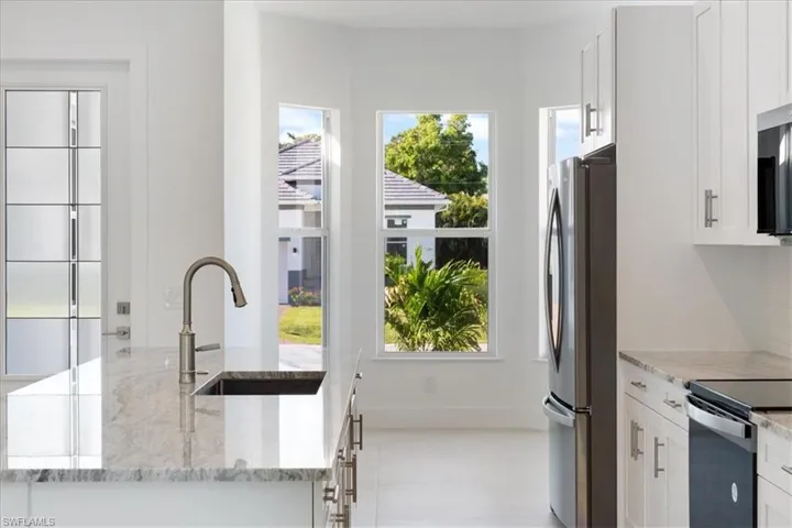Kitchen with plenty of natural light, a sink, white cabinetry, and appliances with stainless steel finishes