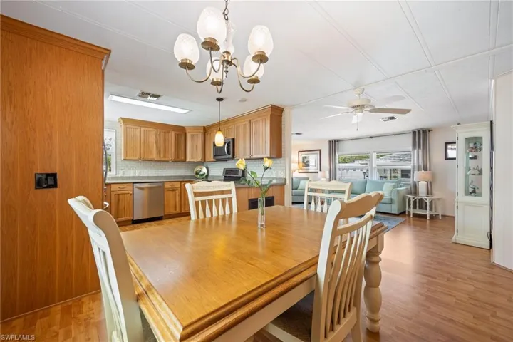 Dining area with suspended lighting, light wood-type flooring, and a ceiling fan