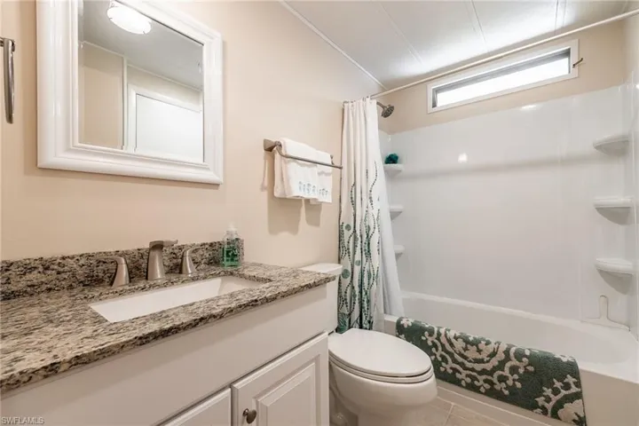 Full bathroom with vanity, shower / tub combo, and light tile patterned flooring