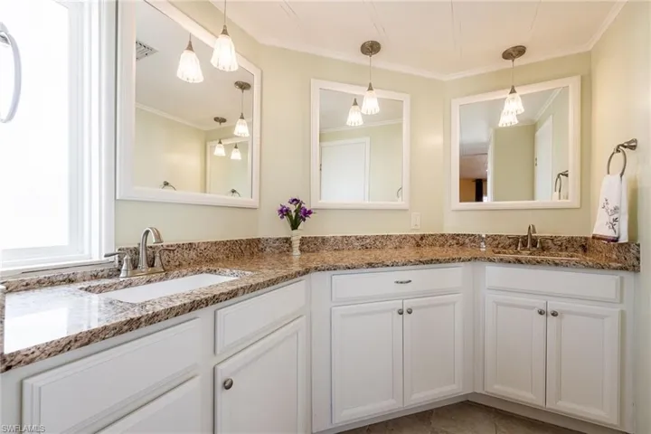 Bathroom with double vanity and ornamental molding