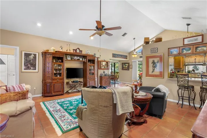 Tiled living room with vaulted ceiling and ceiling fan