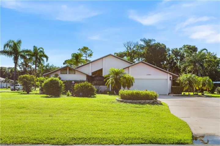 Single story home featuring a garage and a front lawn