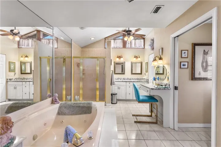 Bathroom with an enclosed shower, vanity, ceiling fan, and tile floors