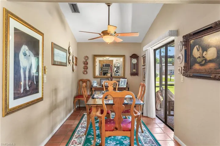 Tiled dining room with vaulted ceiling and ceiling fan