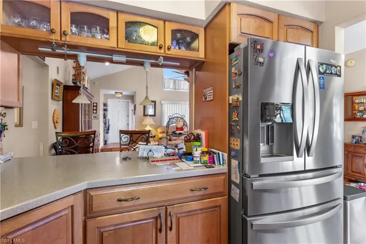 Kitchen with decorative light fixtures and stainless steel fridge with ice dispenser