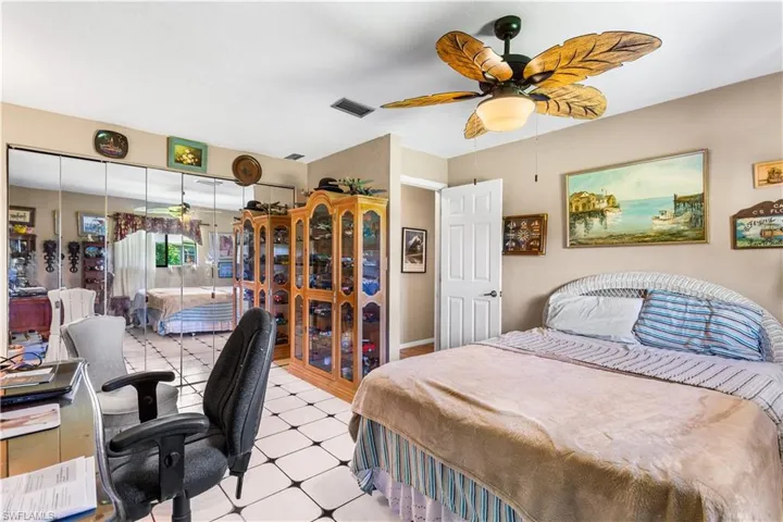 Bedroom with ceiling fan and light tile floors