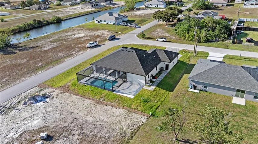 Birds eye view of property with a water view and a residential view