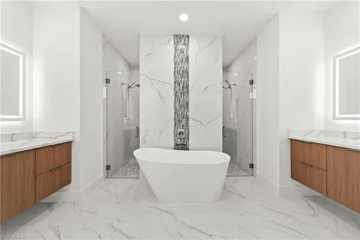 Bathroom featuring a soaking tub, marble finish floor, a marble finish shower, recessed lighting, and vanity
