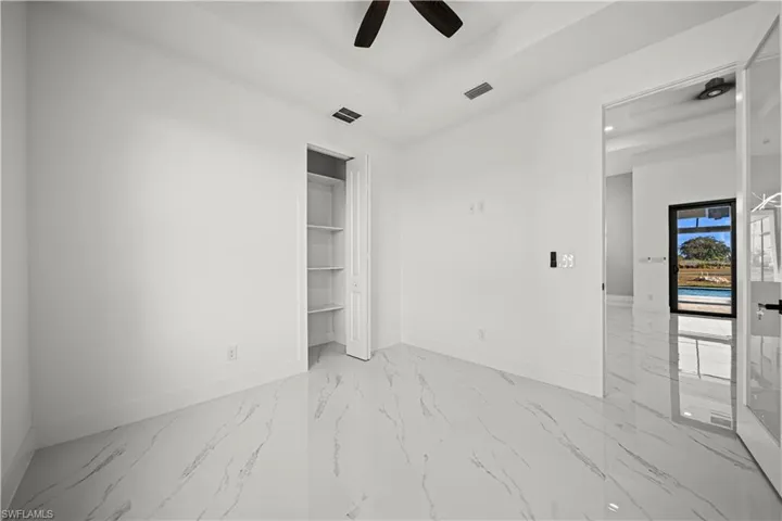 Unfurnished room with a tray ceiling, baseboards, visible vents, and a ceiling fan
