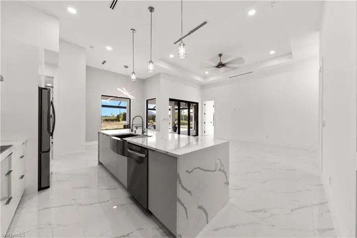 Kitchen with a tray ceiling, marble finish floor, modern cabinets, and stainless steel dishwasher