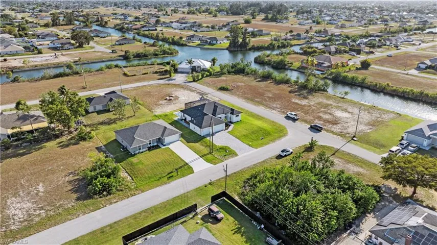 Birds eye view of property with a water view and a residential view