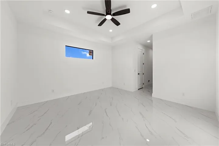 Unfurnished room with recessed lighting, a tray ceiling, baseboards, and visible vents