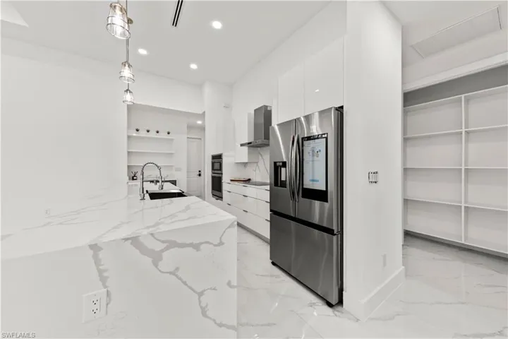 Kitchen featuring modern cabinets, white cabinetry, a sink, and stainless steel appliances
