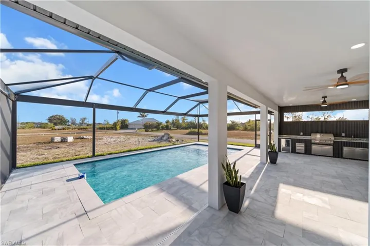 Outdoor pool with area for grilling, a lanai, ceiling fan, and a patio