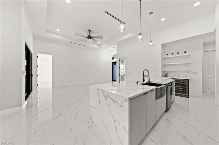 Kitchen with modern cabinets, beverage cooler, open shelves, open floor plan, and a tray ceiling