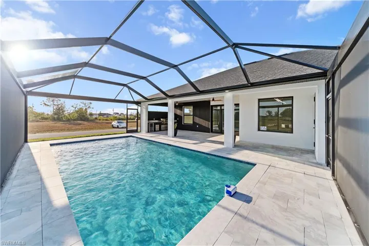 Pool with glass enclosure, ceiling fan, and a patio area