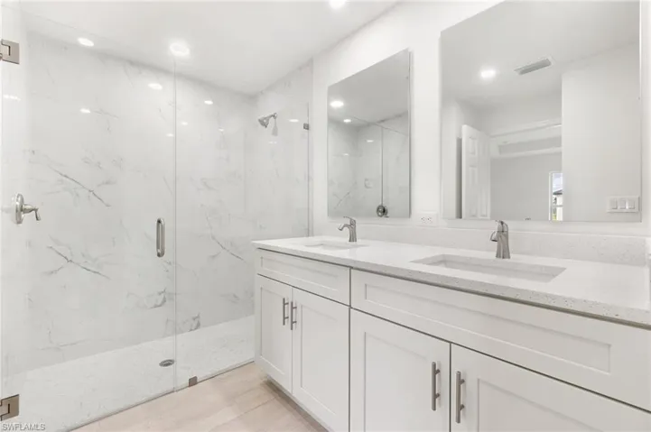 Bathroom featuring vanity and an enclosed shower