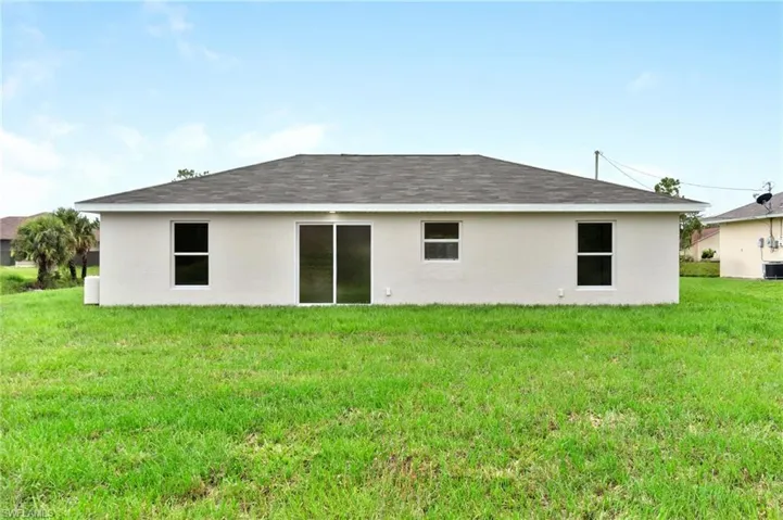 Rear view of property with central AC and a yard