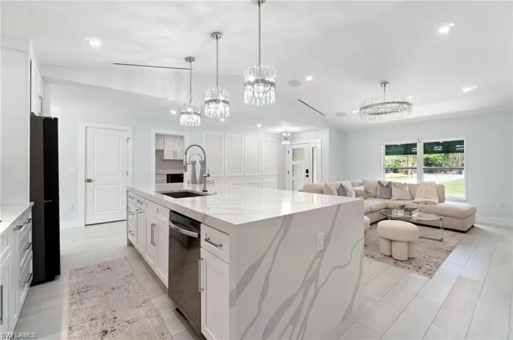 Large entertaining island with imported Pompei quartz, chandeliers, large walk-in pantry with custom cabinets and shelving, Wolf induction cooktop.