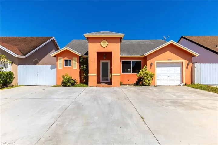 View of front of home featuring stucco siding, fence, concrete driveway, and a garage