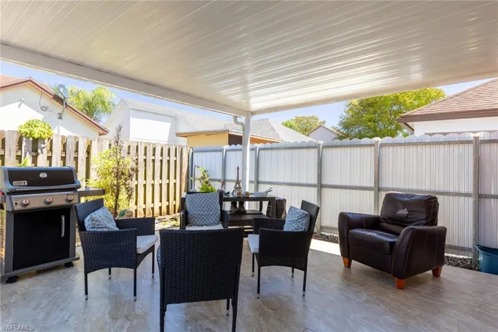 View of patio with outdoor dining area, a fenced backyard, and area for grilling
