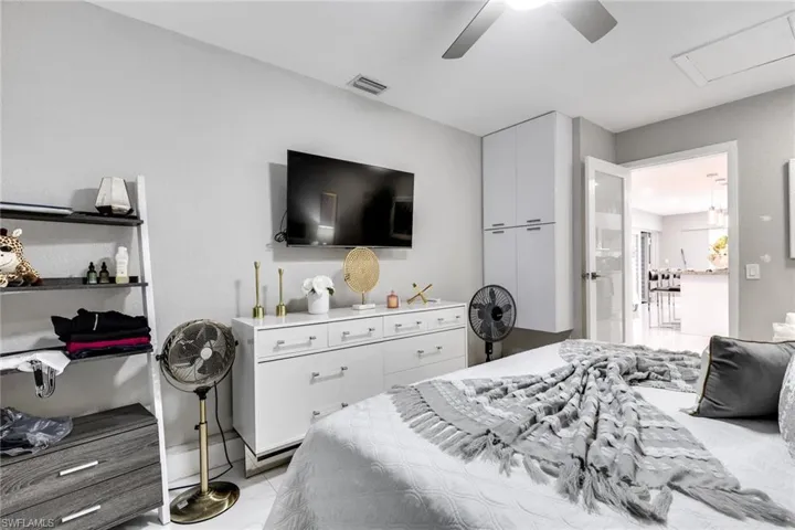 Bedroom with visible vents, marble finish floor, and ceiling fan
