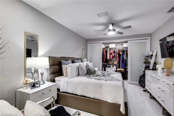 Bedroom featuring visible vents, marble finish floor, and ceiling fan