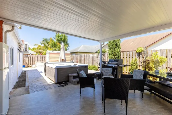View of patio / terrace featuring a fenced backyard, a grill, and a hot tub