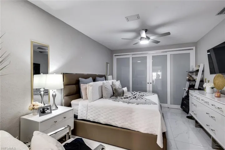 Bedroom with visible vents, marble finish floor, a ceiling fan, and french doors