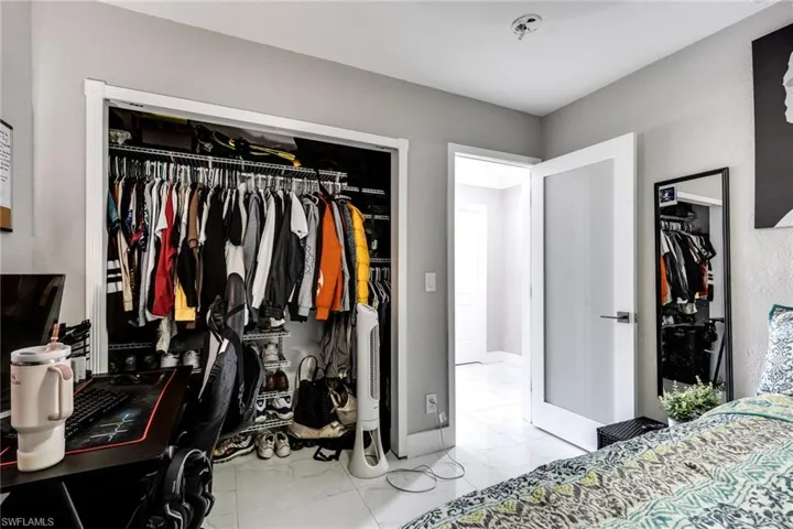 Bedroom with marble finish floor and a closet