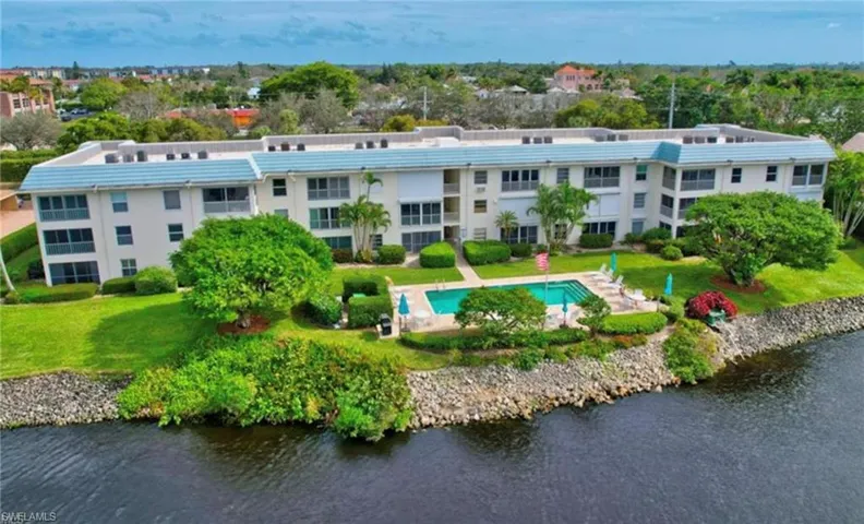 Drone / aerial view of a nearby body of water and a pool area