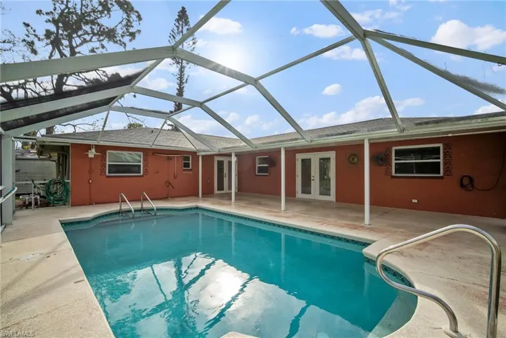 View of swimming pool featuring a lanai, french doors, and a patio