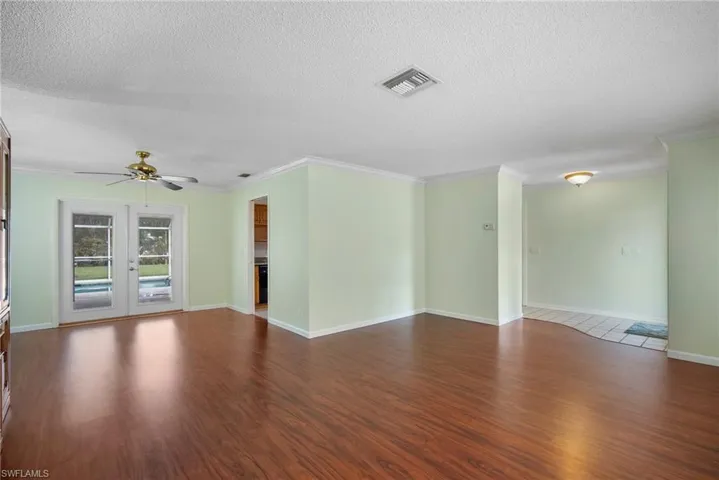 Spare room with french doors, hardwood / wood-style flooring, ceiling fan, and a textured ceiling
