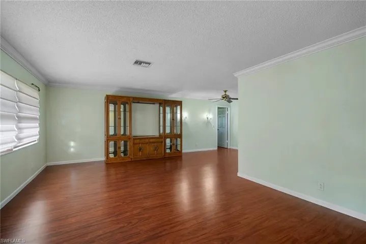 Spare room featuring dark wood-type flooring and a textured ceiling