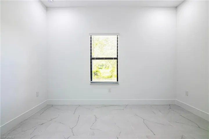 Unfurnished room featuring baseboards and light marble finish flooring