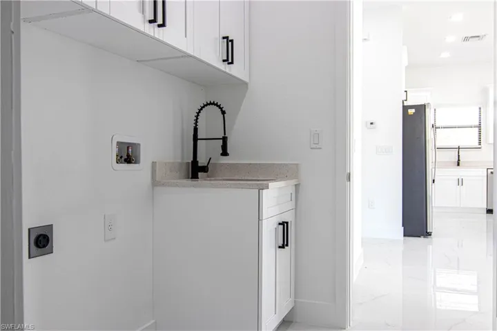 Laundry room featuring cabinet space, light marble finish flooring, hookup for a washing machine, electric dryer hookup, and recessed lighting