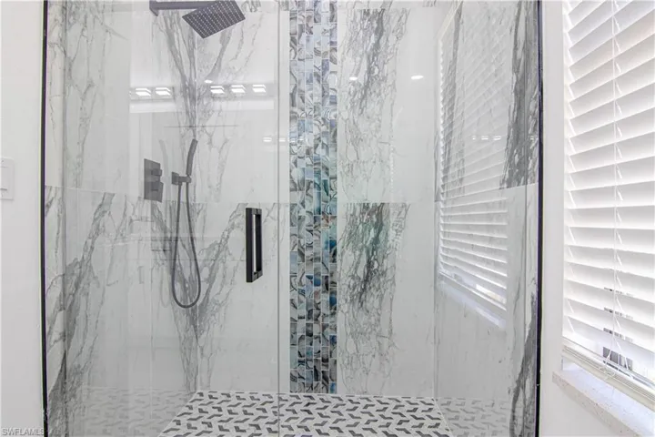 Bathroom with a marble finish shower