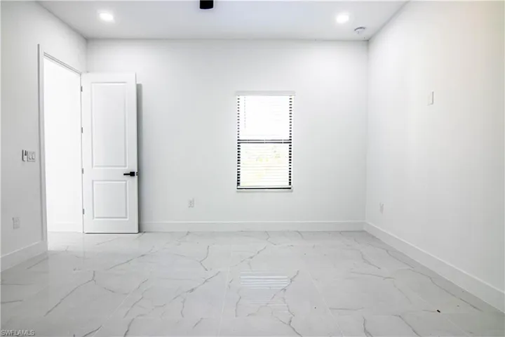 Unfurnished room with recessed lighting and light marble finish flooring