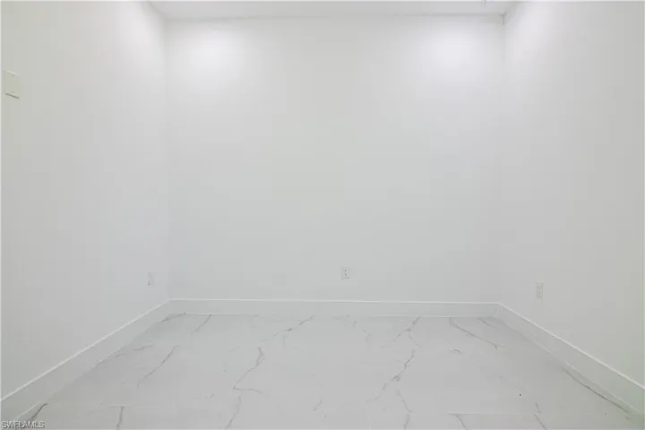 Spare room with baseboards and light marble finish flooring