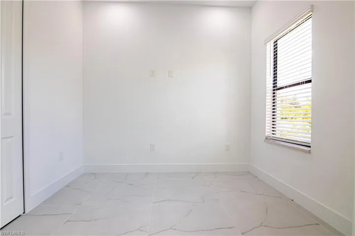 Unfurnished room with baseboards and light marble finish flooring