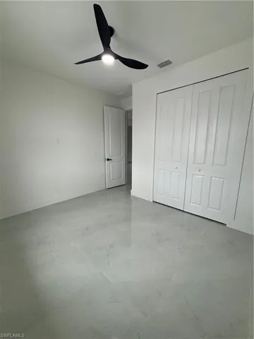 Unfurnished bedroom featuring ceiling fan and a closet