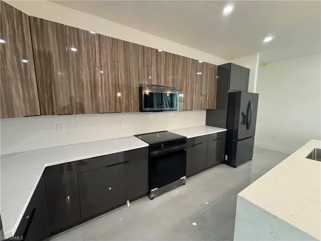Kitchen featuring dark brown cabinets and appliances with stainless steel finishes