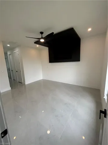 Unfurnished living room featuring ceiling fan